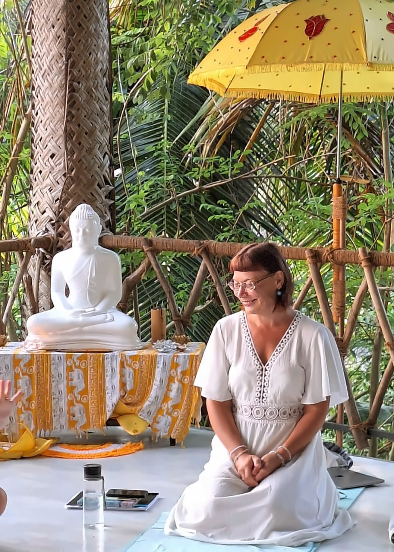 Maivi Talving valges kleidis naeratab Sri Lankal Buddha kuju kõrval